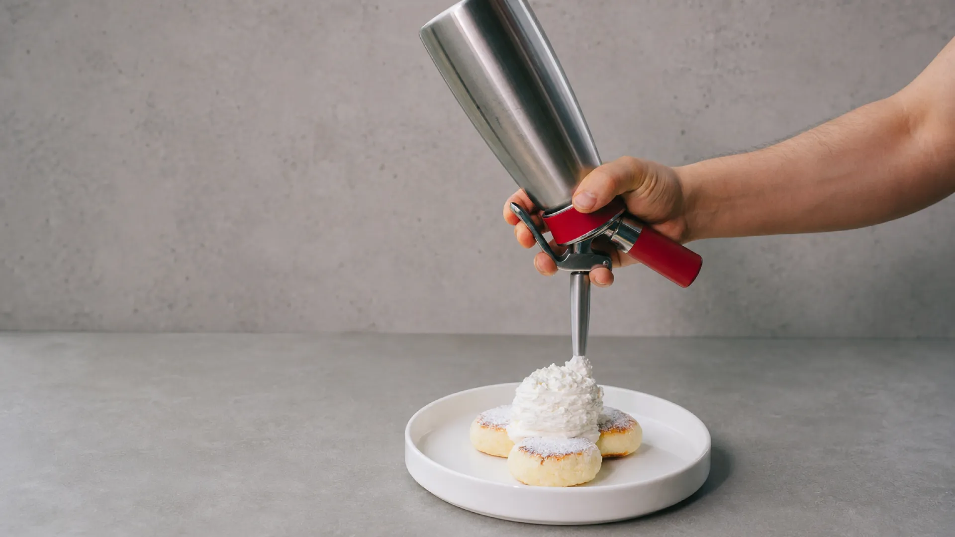 Cross-section diagram of a whipped cream dispenser showing charger, gas headspace, and cream inside | Champion Whip